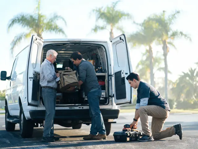 A field team loading equipment into a service van in the morning.